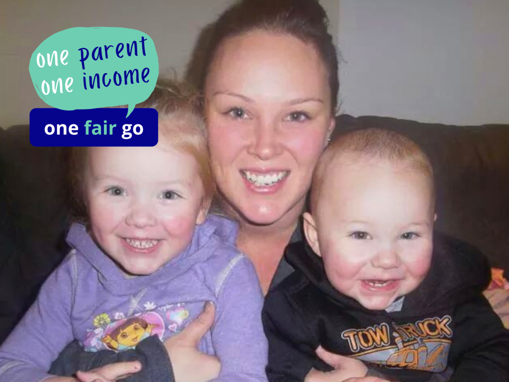 Young mother with her two young children, all smiling at camera.